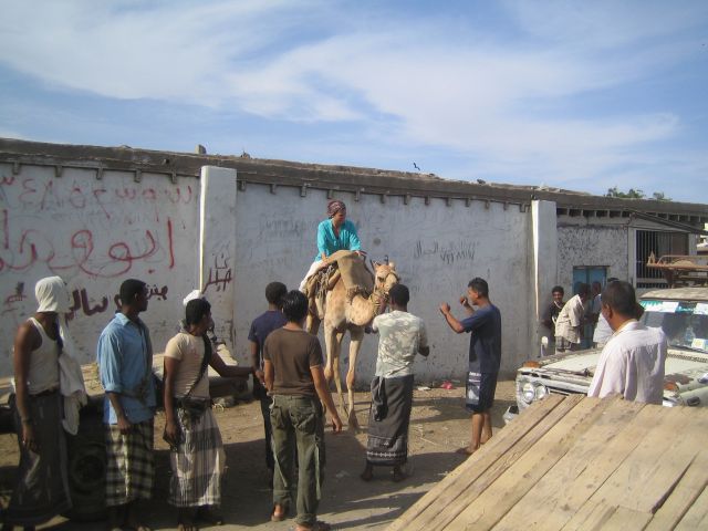 Amy riding camel having fun with locals in Aden