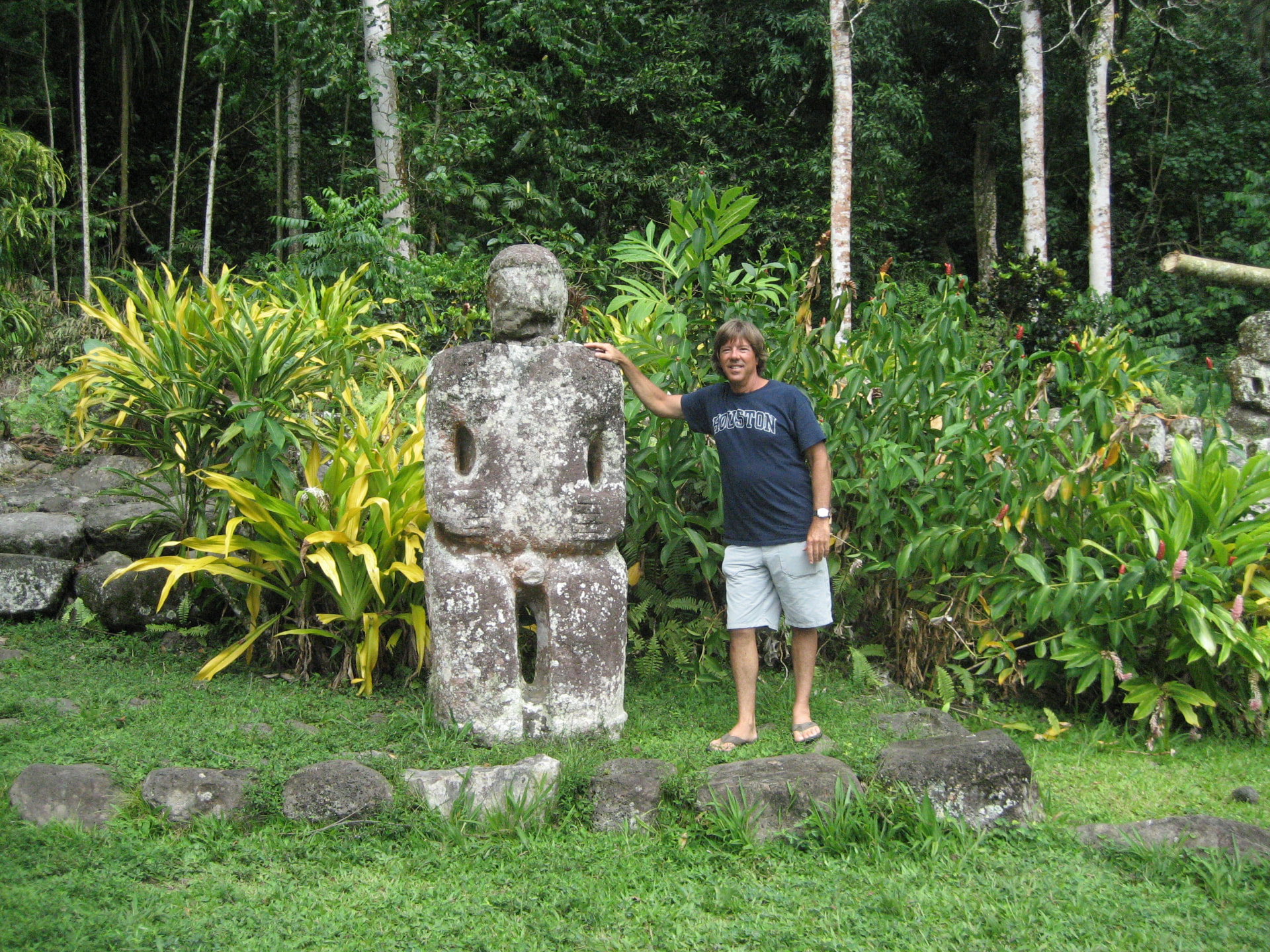 Russell with a stone tiki in the jungle, Marquesas Islands