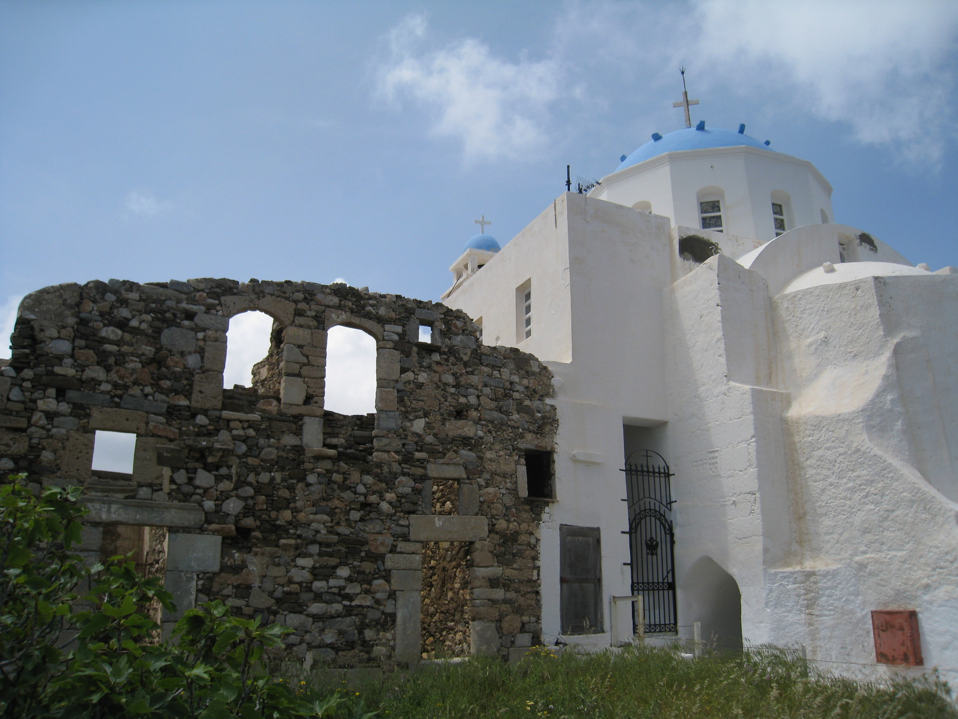 A blue-domed church beside the old stone ruins
