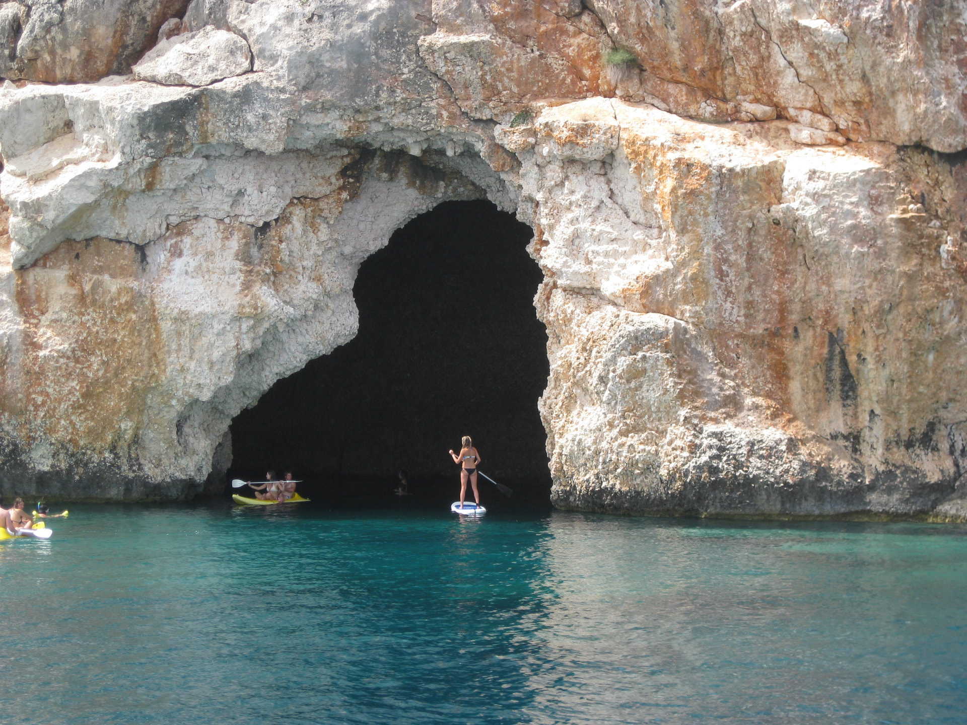Kristi paddle boarding toward the sea cave entrance, Turkey